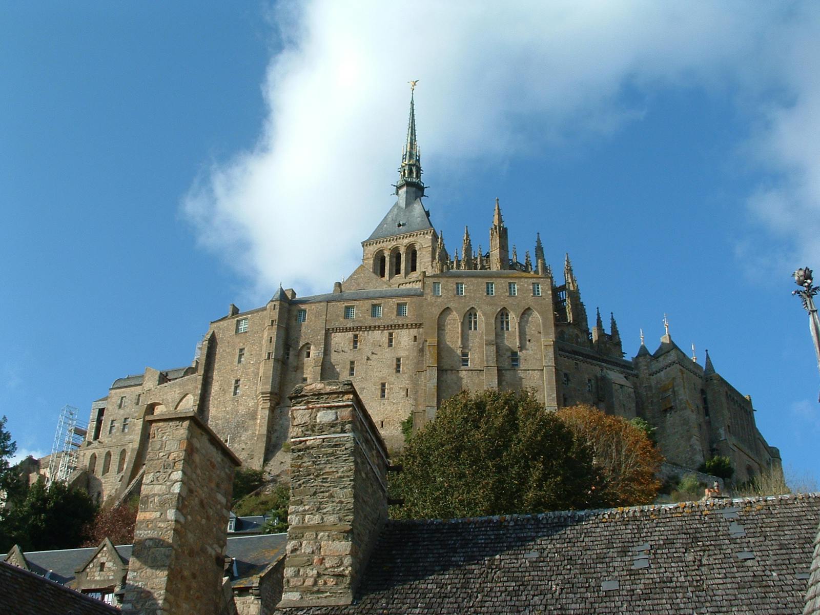 Lågvinkelutsikt over Abbediet på Mont Saint-Michel under den blå himmelen