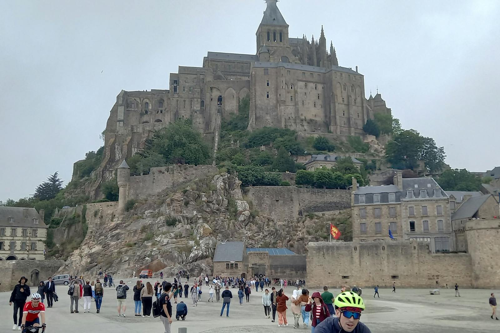 Lavt perspektiv av L'Abbaye du Mont Saint-Michel med folkemengde